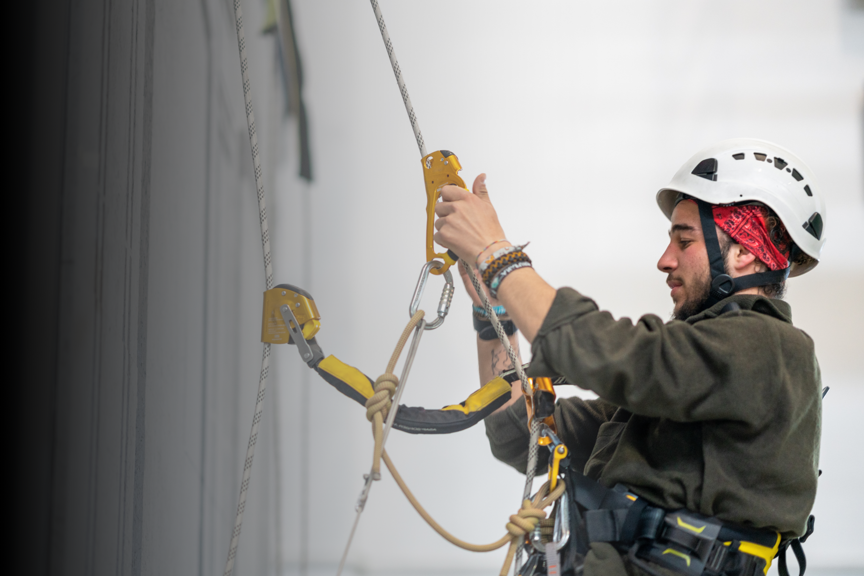 Man scales side of building with workers safety equipment