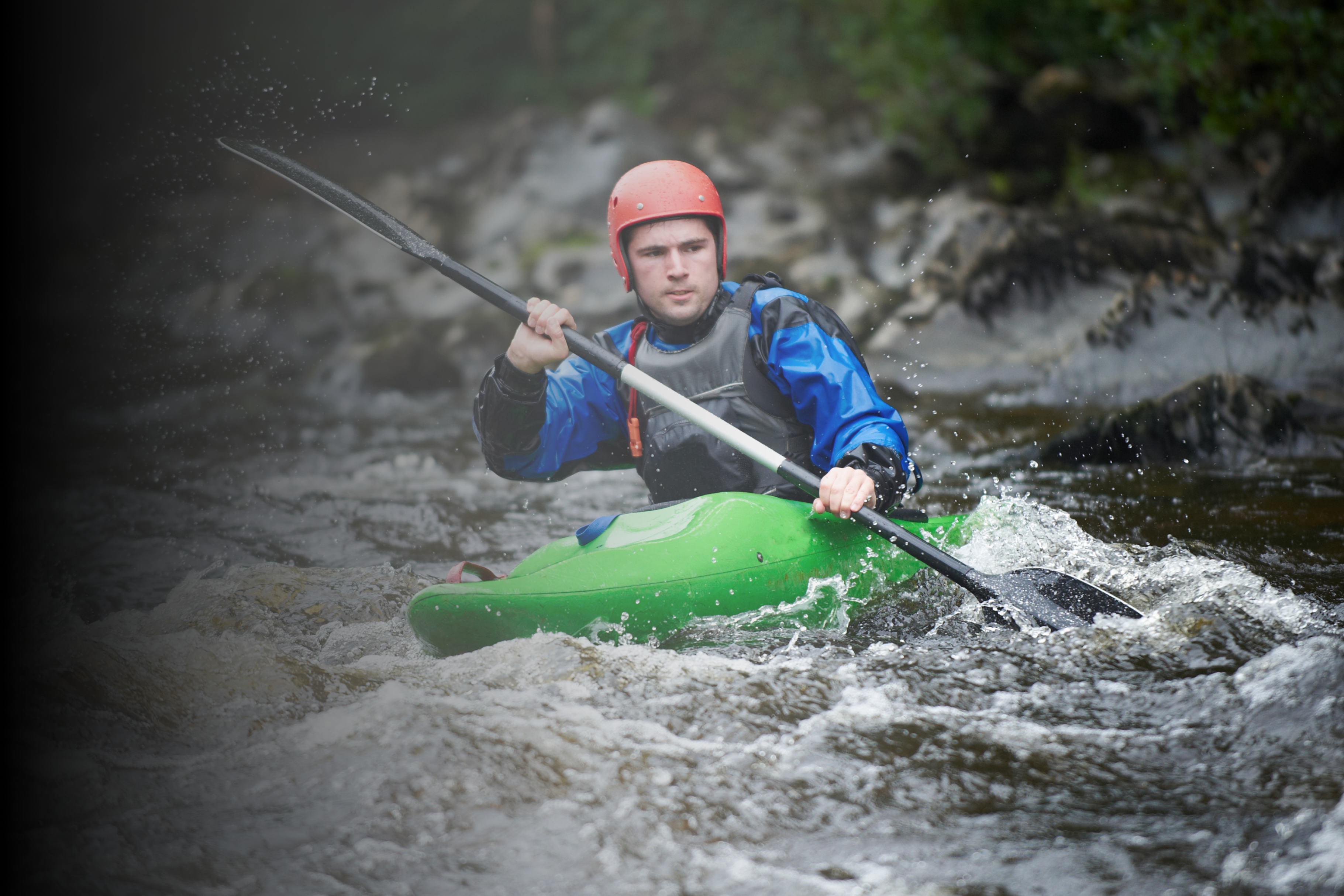 Kayaker navigating through a section of white water rapids